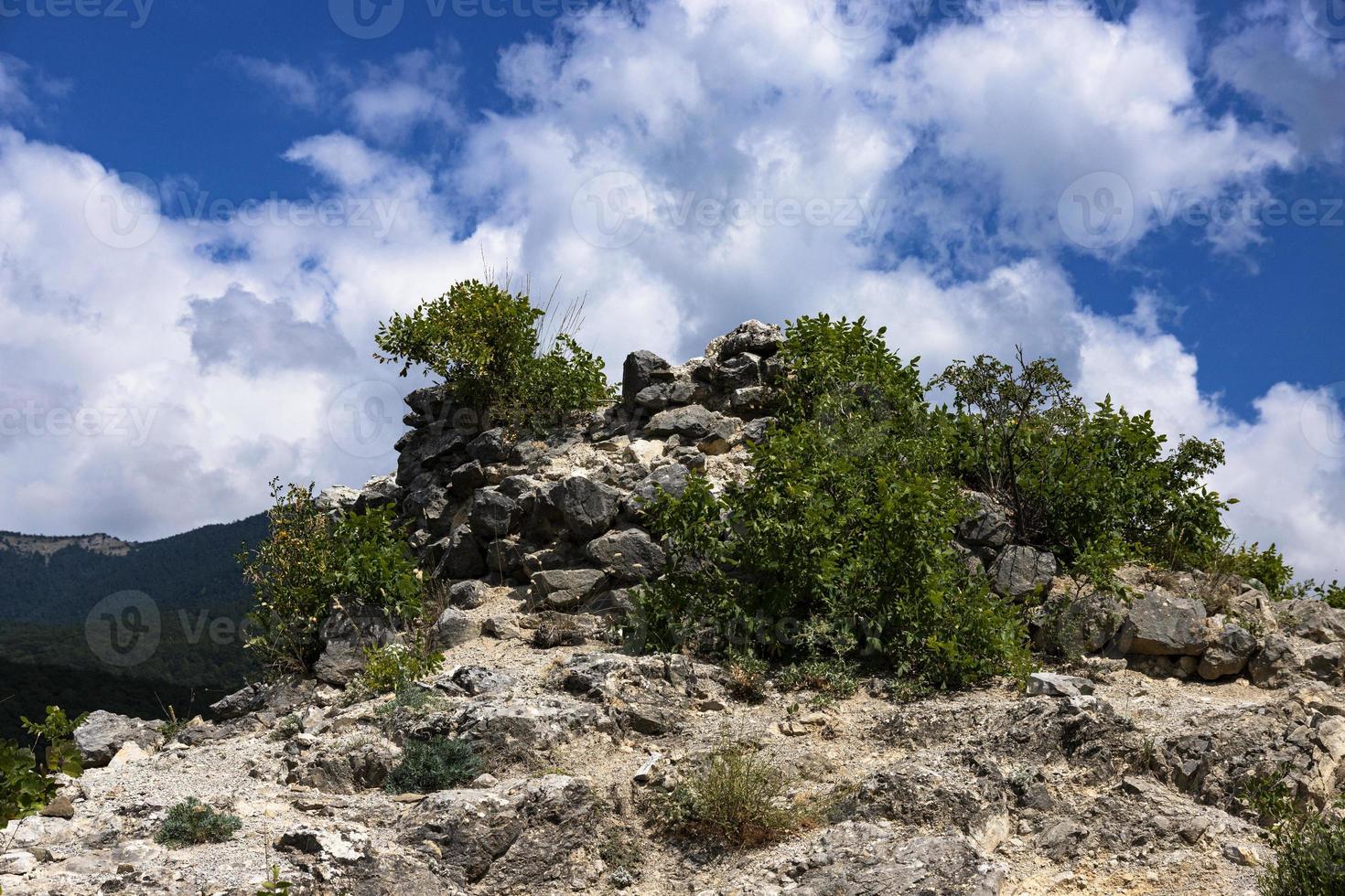 Berggipfel, der Gipfel eines Berges mit einer zerstörten Festung an der Spitze vor einem Himmel mit Wolken. foto