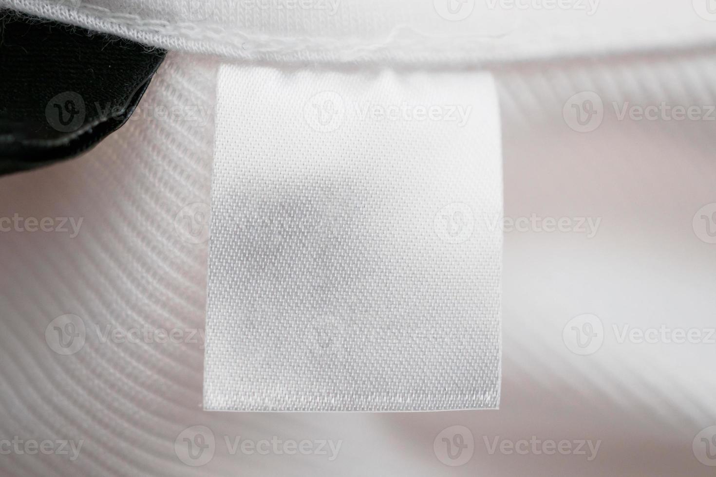 weißes leeres Kleidungsetikett auf Baumwollhemdhintergrund foto