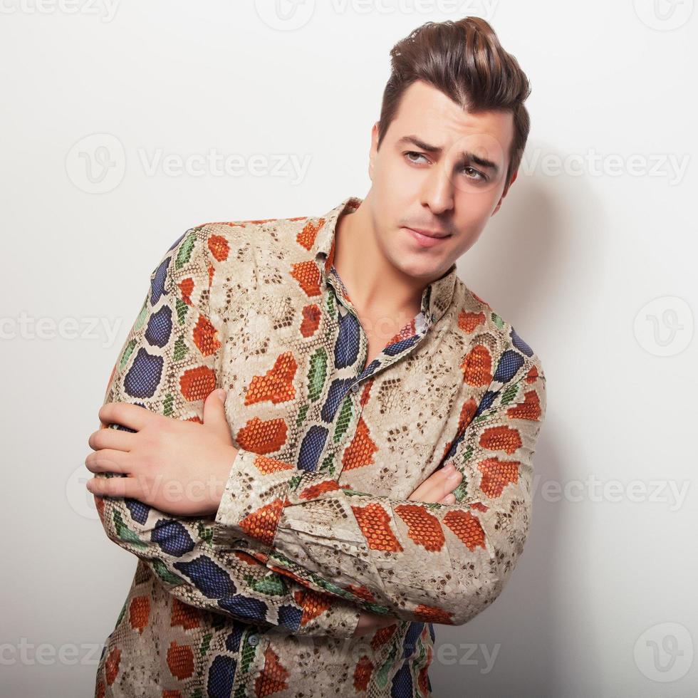 eleganter junger hübscher Mann im hellen bunten Hemd. foto