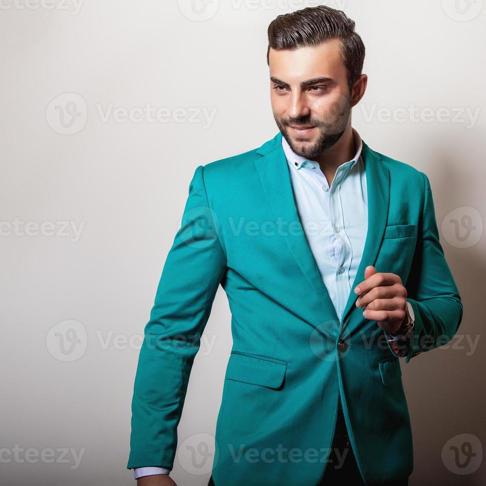 eleganter junger gutaussehender Mann in stilvoller türkisfarbener Jacke. foto