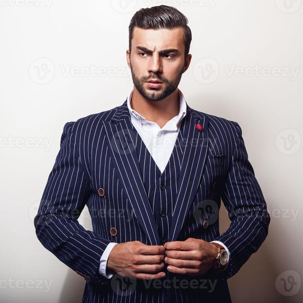 eleganter junger hübscher Mann im klassischen dunkelblauen Kostüm. foto