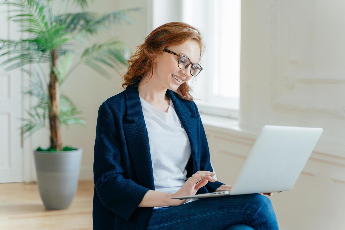 seitliche aufnahme eines finanzexperten bereitet bericht über notebook vor, tastaturinformationen auf laptop-computer, durchsucht informationen auf laptop-computer, gekleidet in formelle kleidung, entwickelt startprojekt foto