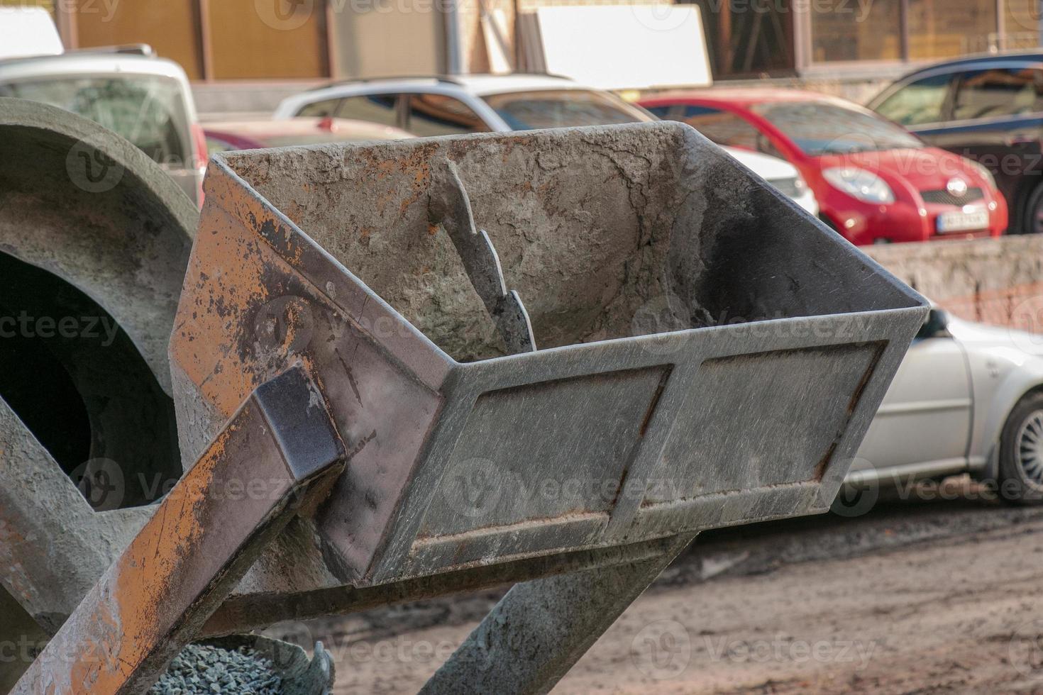 Mobiler Betonmischer auf der Baustelle. Nahaufnahme von Kies, der in eine Betonherstellungsmaschine geladen wird foto