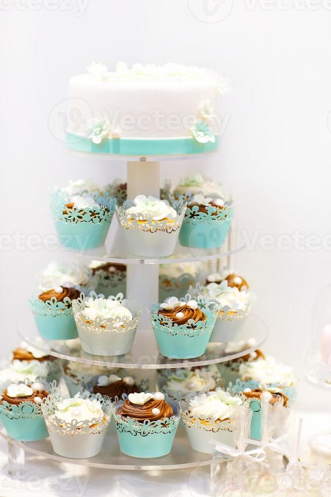 Hochzeitstorte und Cupcakes in Braun und Creme foto