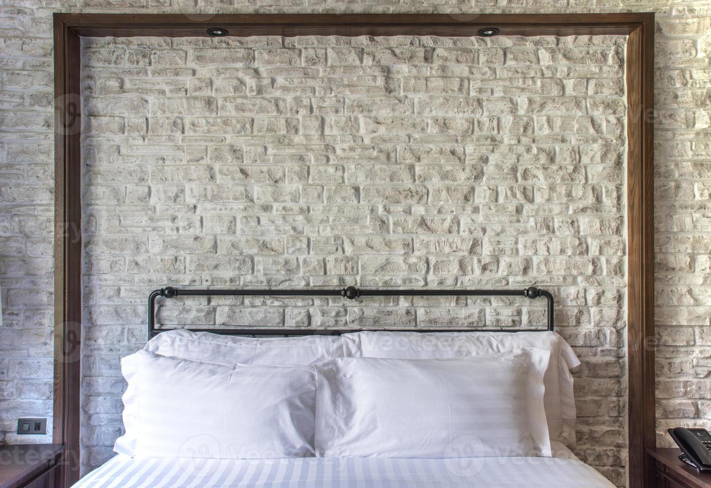 weiße Kissen auf einem klassischen Schlafzimmer mit weißer Backsteinmauer foto
