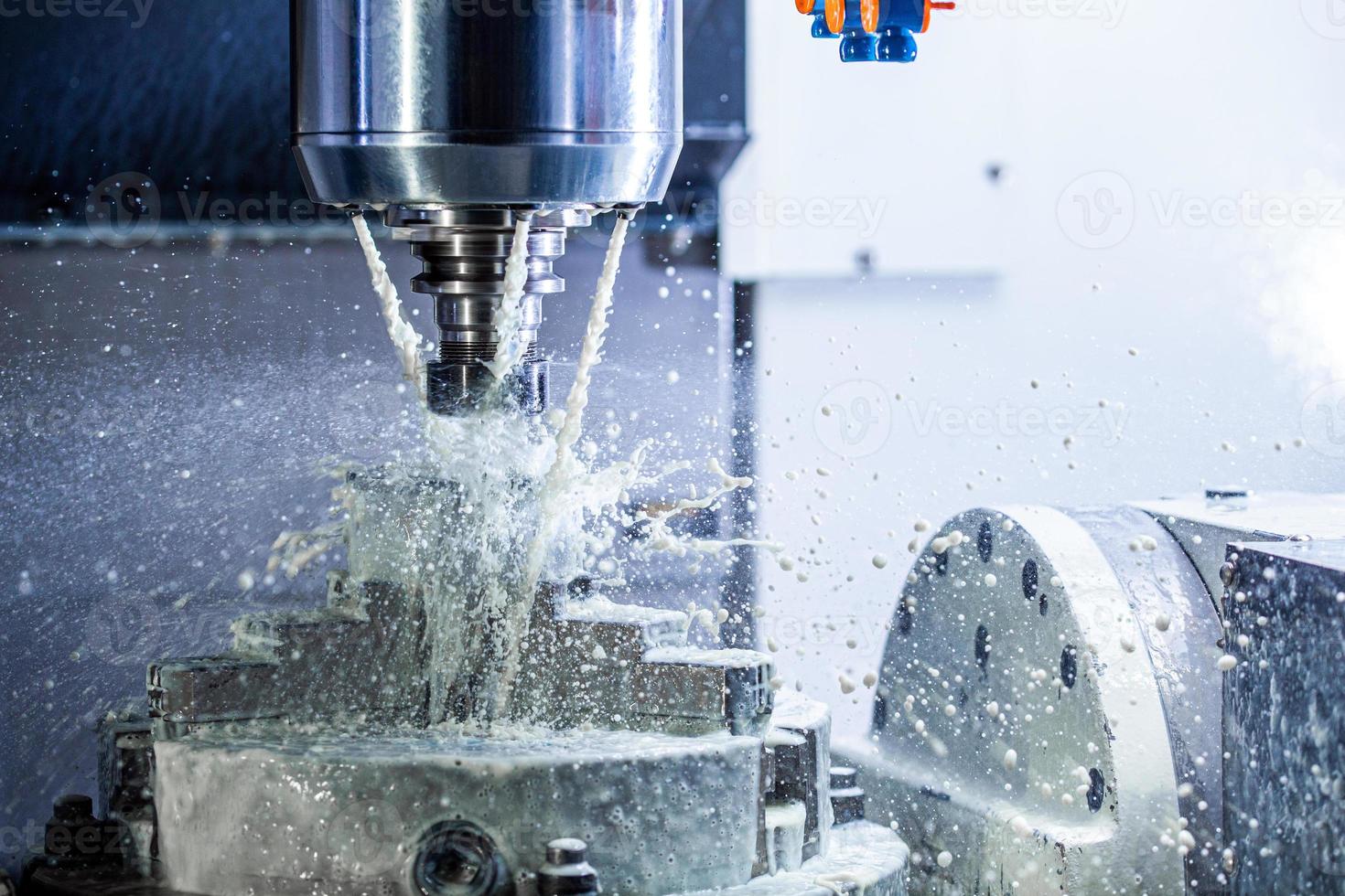 ein Prozess des industriellen Nassfräsens in einer 5-Achsen-CNC-Maschine mit Kühlmittelfluss unter Druck und gefrorenen Spritzern foto