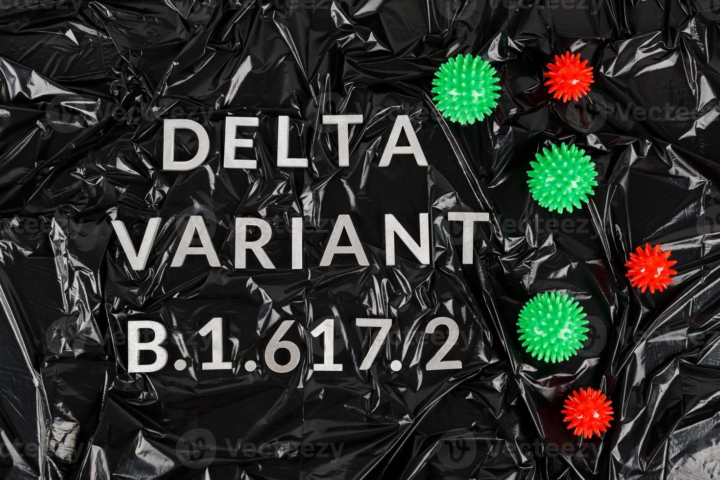 Wörter Delta-Variante b.1.617 mit silbernen Metallbuchstaben auf zerknittertem schwarzem Plastiktütenhintergrund in diagonaler Perspektive foto