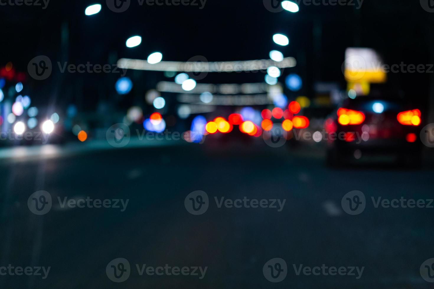 Defokussiertes Bild des nächtlichen Straßenverkehrs - Blick von der Straße. bunter hintergrund des nachtlebens. foto