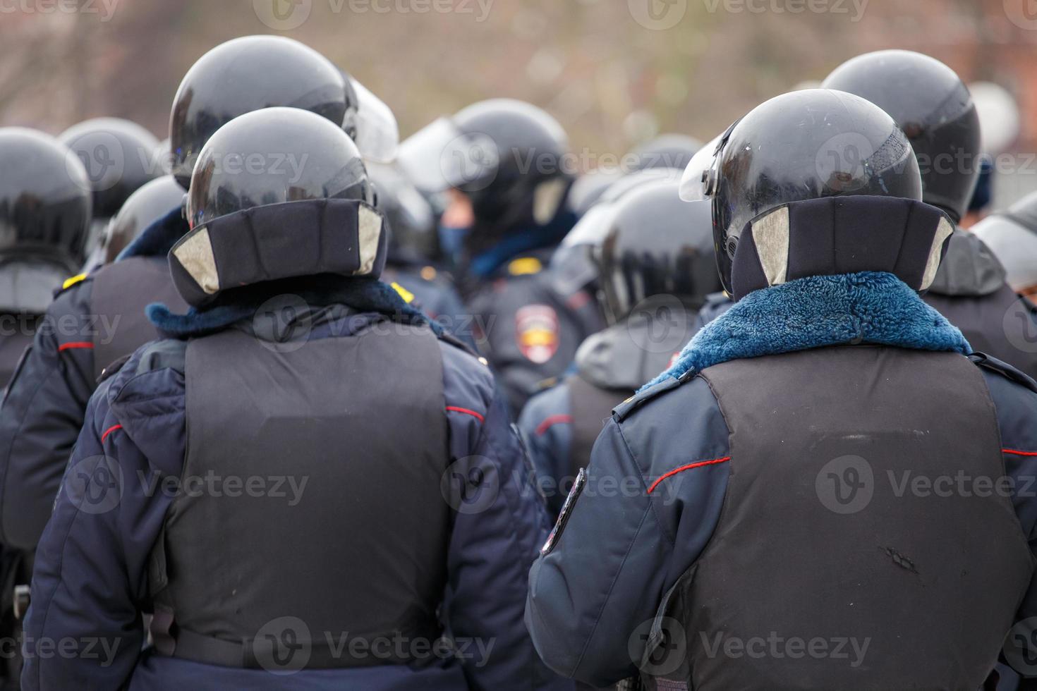 Polizisten in schwarzen Helmen warten auf den Befehl, die Demonstranten festzunehmen. foto