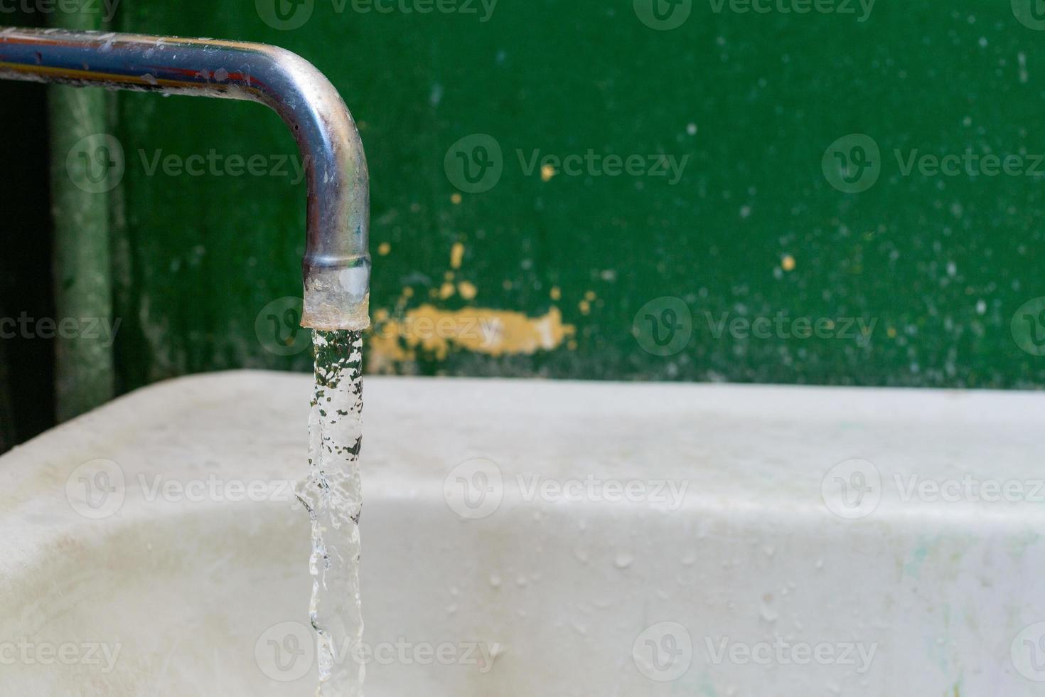 Nahaufnahme des alten befleckten Wasserhahns mit selektivem Fokus und Hintergrundunschärfe foto