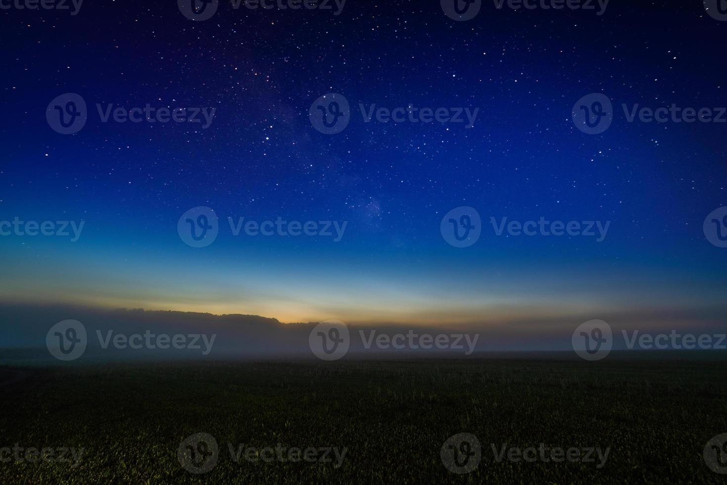 nebeliges nachtfeld mit sternenklarem nachthimmel und nachleuchtendem horizontgradienten foto