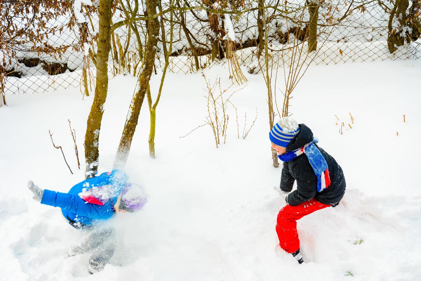 Zwei Jungen spielen Schneebälle, ein lustiges Spiel im Winter, eine glückliche Kindheit für Kinder. foto