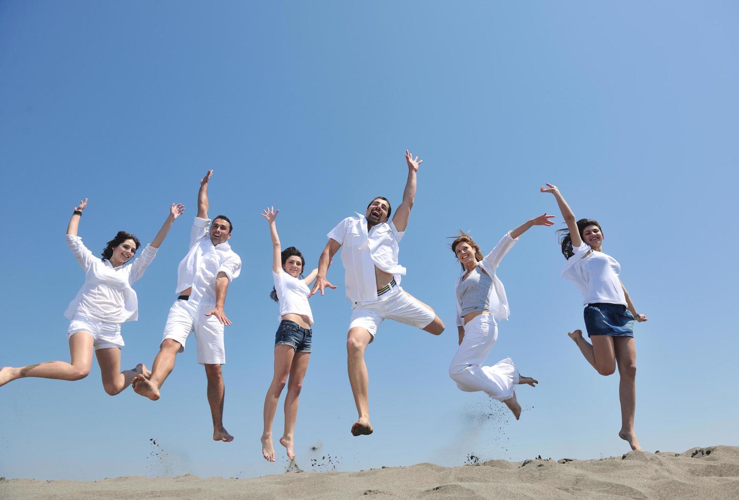 Happy People Group hat Spaß und läuft am Strand foto