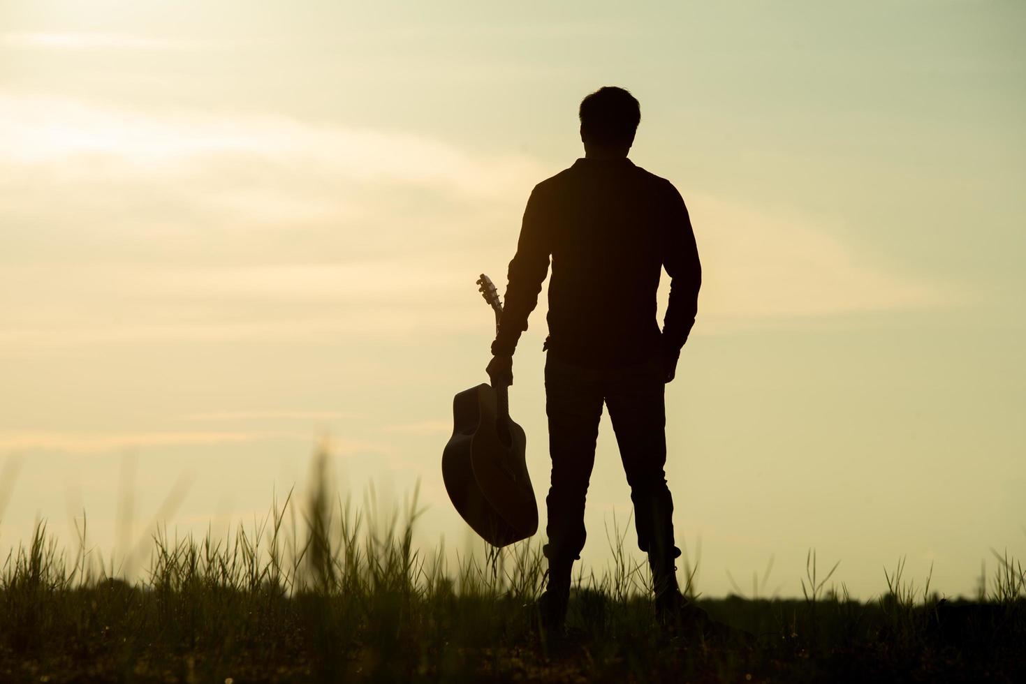 Mann hält akustische Gitarre foto