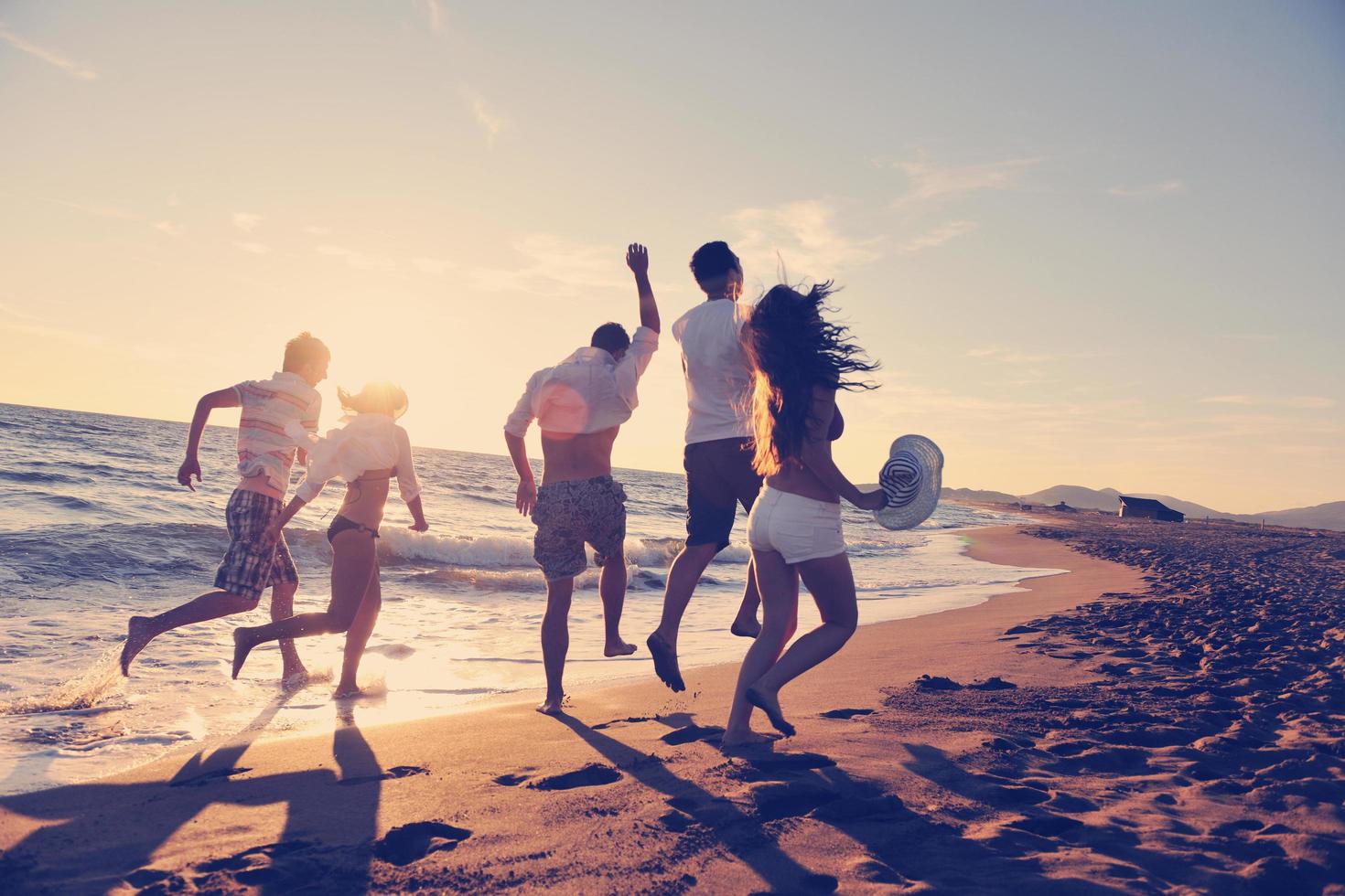 volksgruppe, die am strand läuft foto