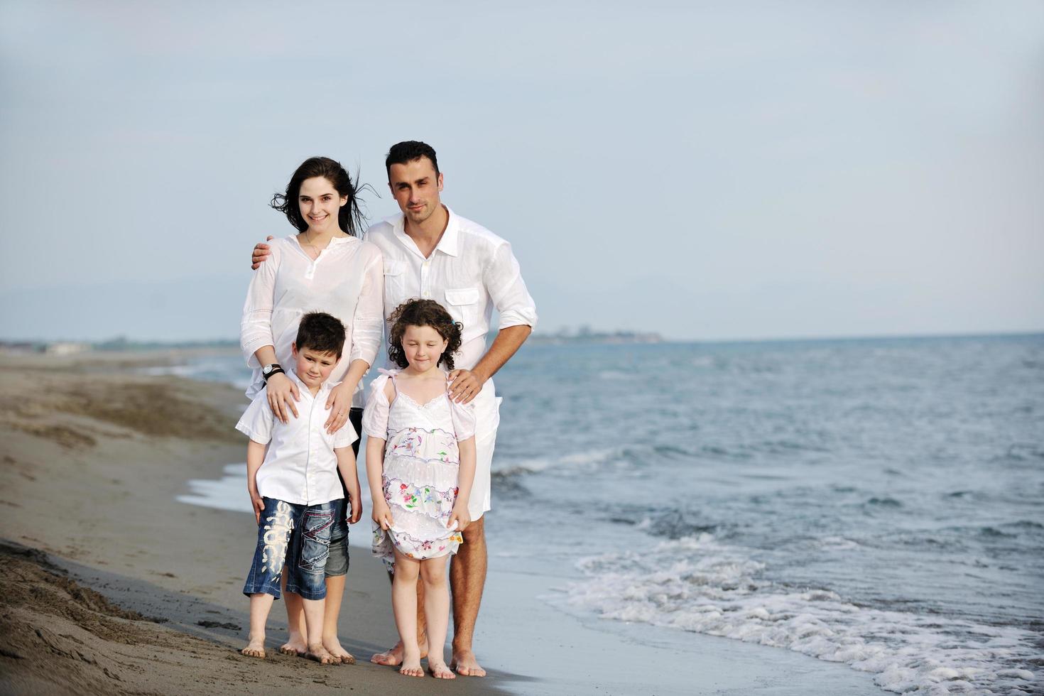 glückliche junge familie hat spaß am strand foto