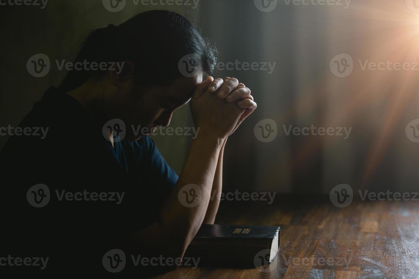 Gebetspersonenhand im schwarzen Hintergrund. christlich-katholische frau betet in der kirche im dunkeln zu gott. Mädchen glauben und glauben an Jesus Christus. christusreligion und christentum verehren oder beten konzept. foto