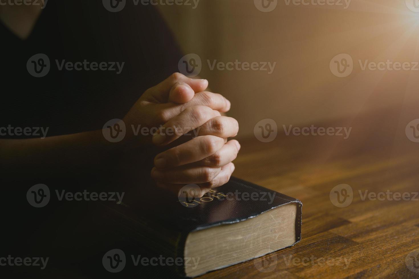 Gebetspersonenhand im schwarzen Hintergrund. christlich-katholische frau betet in der kirche im dunkeln zu gott. Mädchen glauben und glauben an Jesus Christus. christusreligion und christentum verehren oder beten konzept. foto