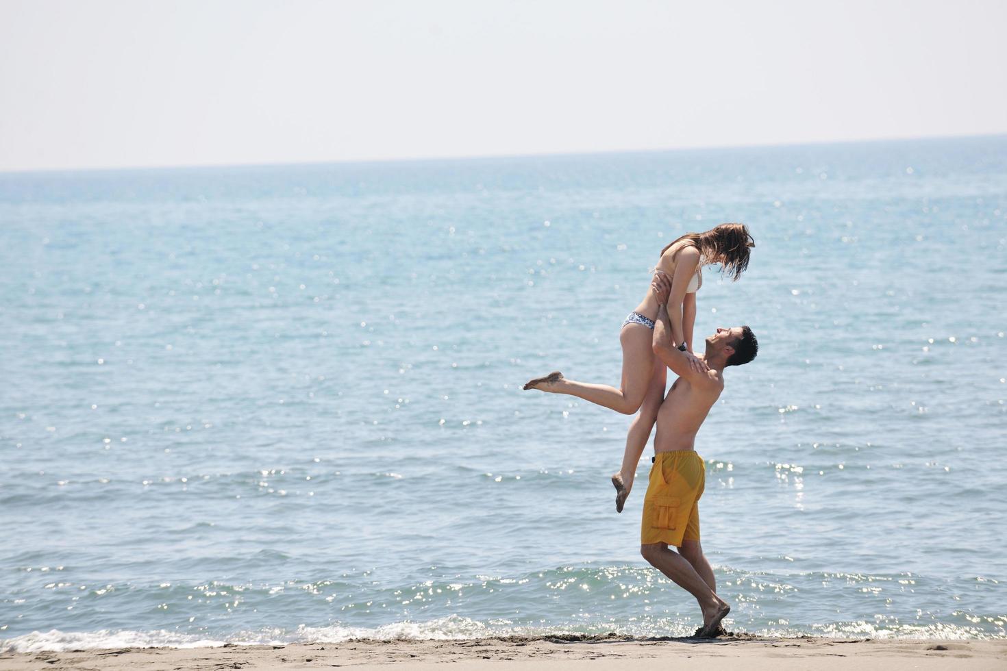 glückliches junges Paar viel Spaß am Strand foto