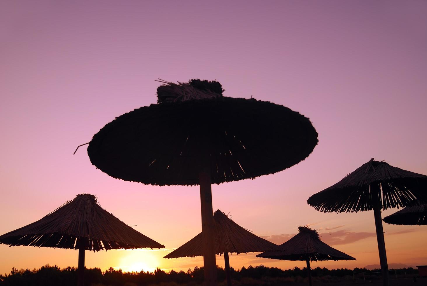 Sonnenschein am Strand mit Sonnenschirmen Silhouette foto