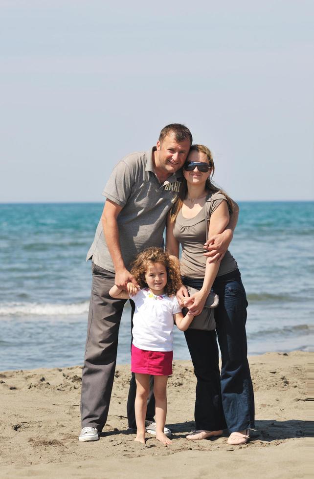 glückliche junge familie hat spaß am strand foto