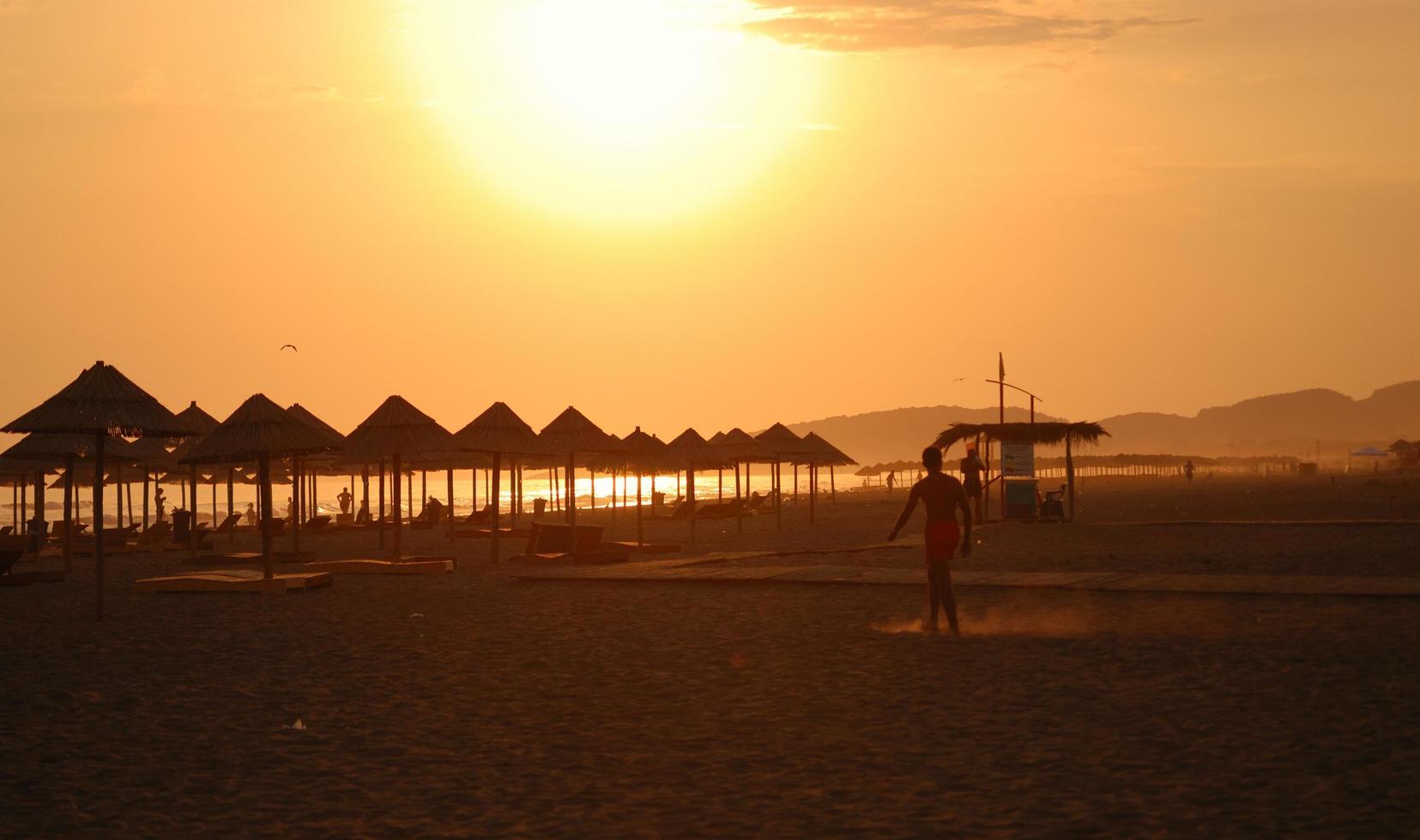 Sonnenschein am Strand mit Sonnenschirmen Silhouette foto