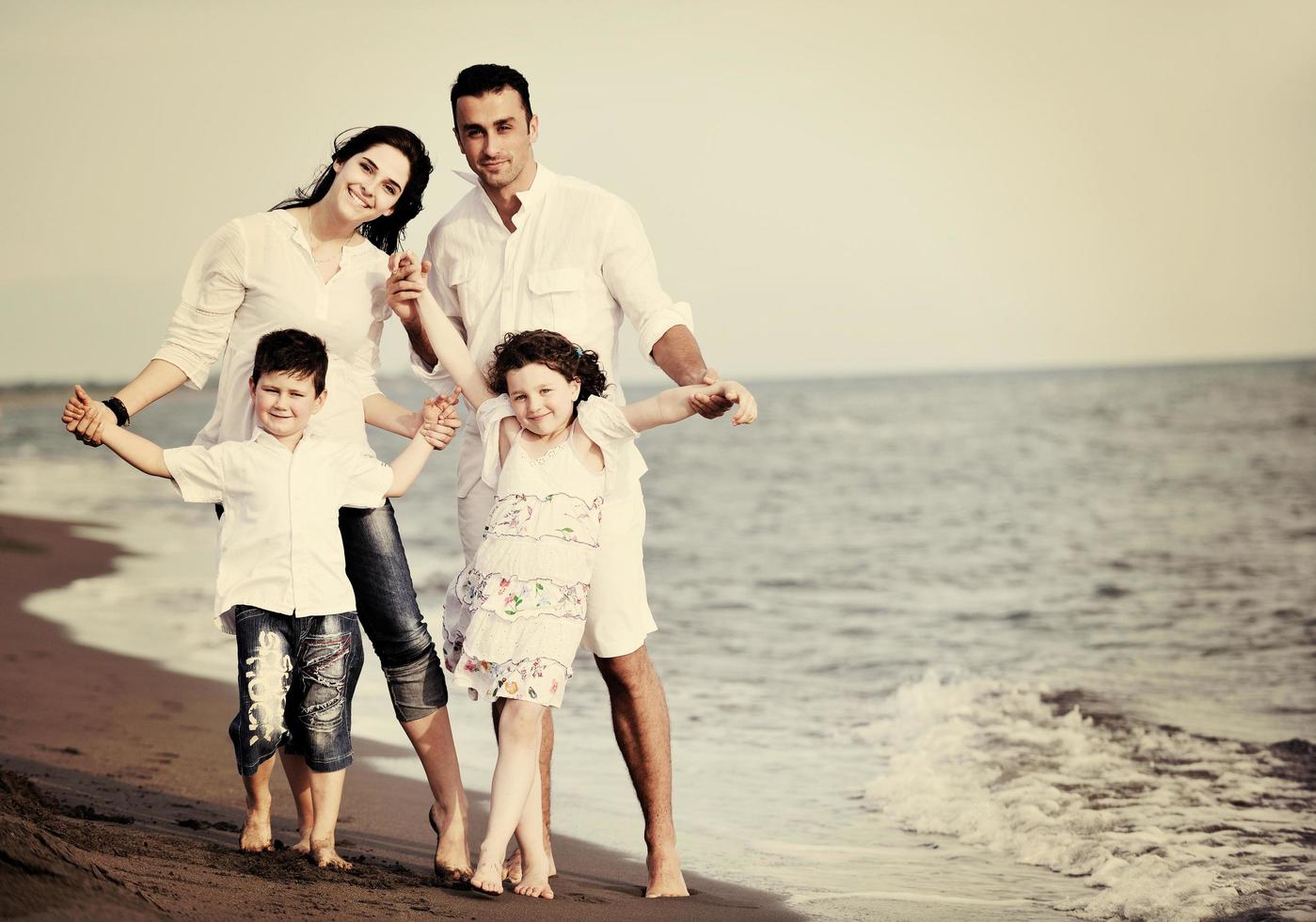 glückliche junge familie hat spaß am strand foto