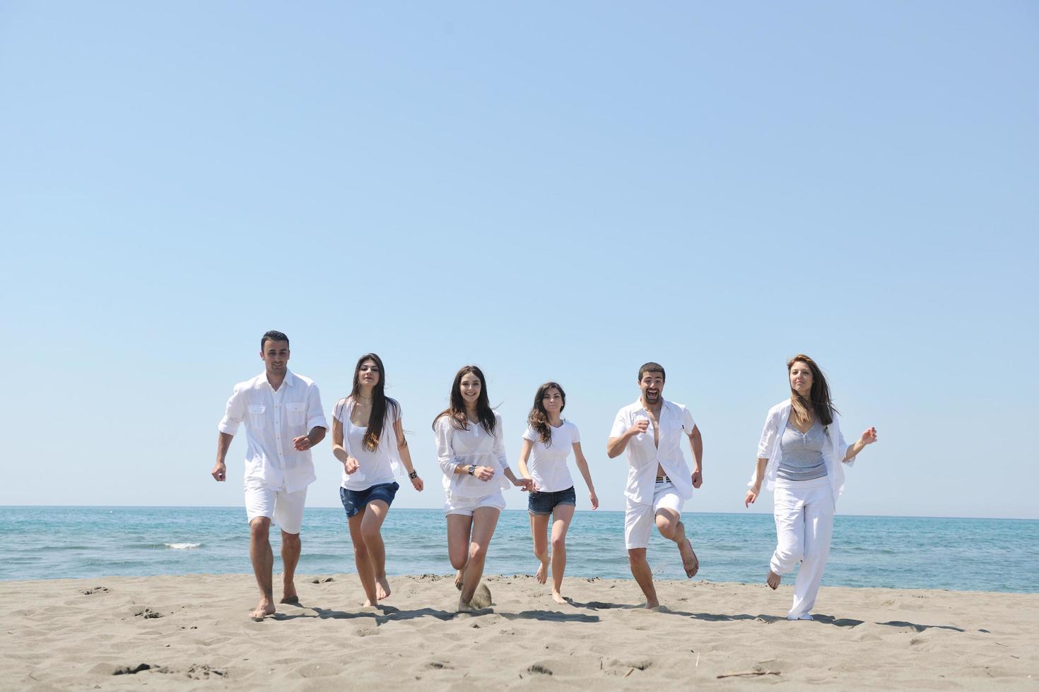 Happy People Group hat Spaß und läuft am Strand foto