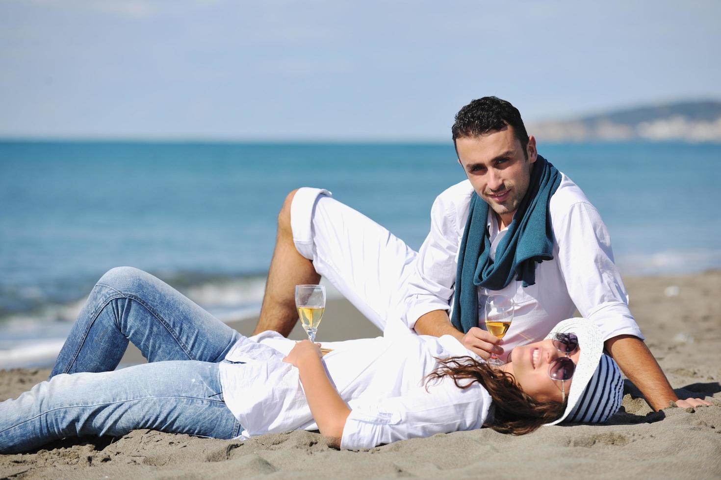 junges Paar beim Picknick am Strand foto