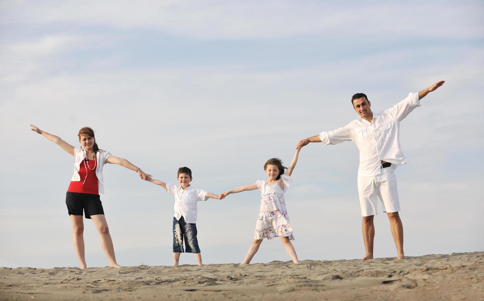 glückliche junge familie hat spaß am strand foto