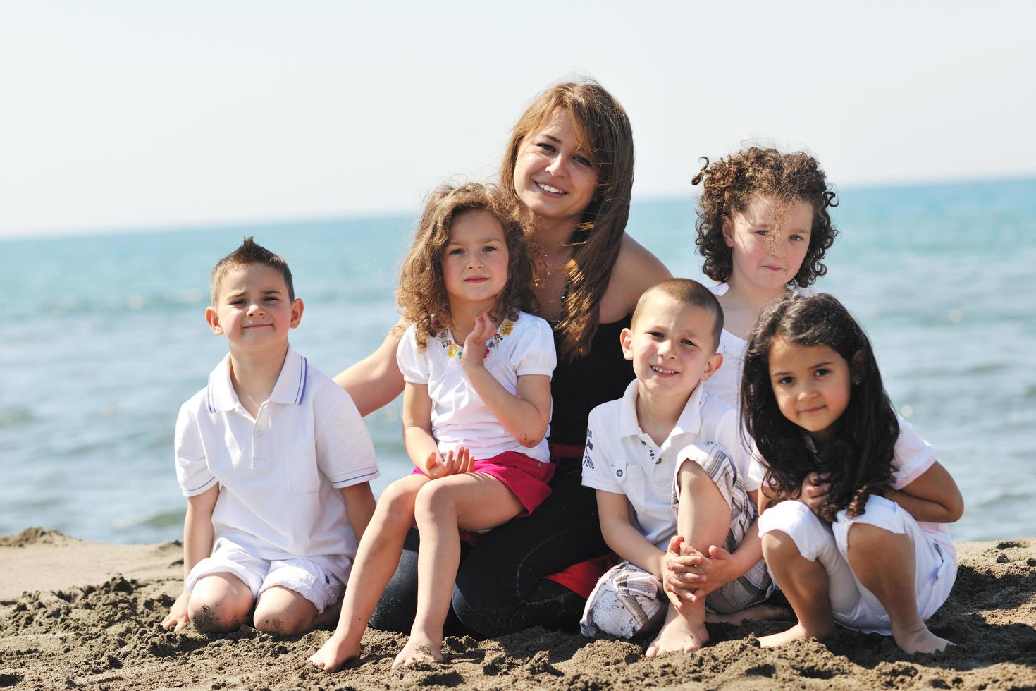 Gruppenporträt von Kindern mit Lehrer am Strand foto
