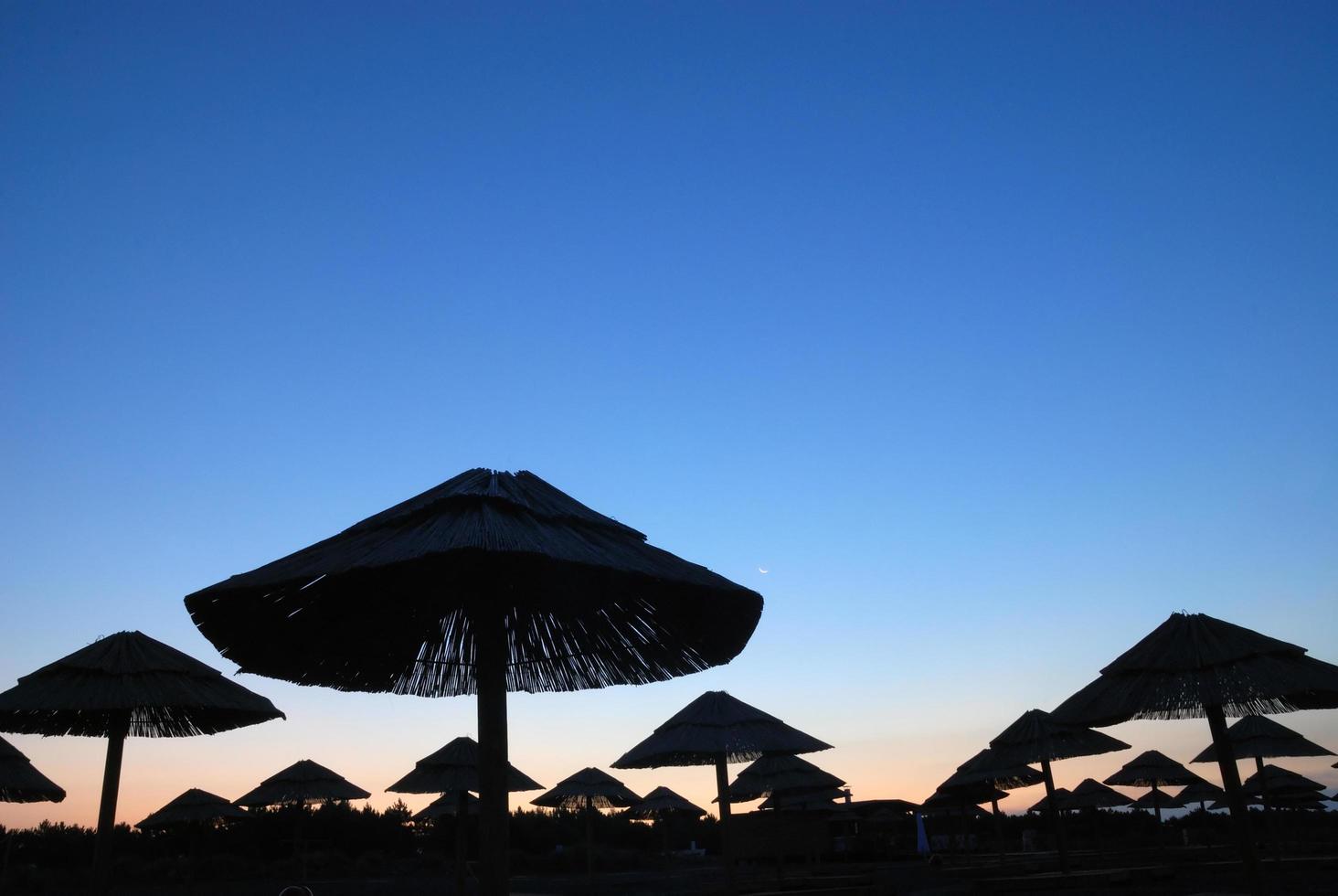 Sonnenschein am Strand mit Sonnenschirmen Silhouette foto