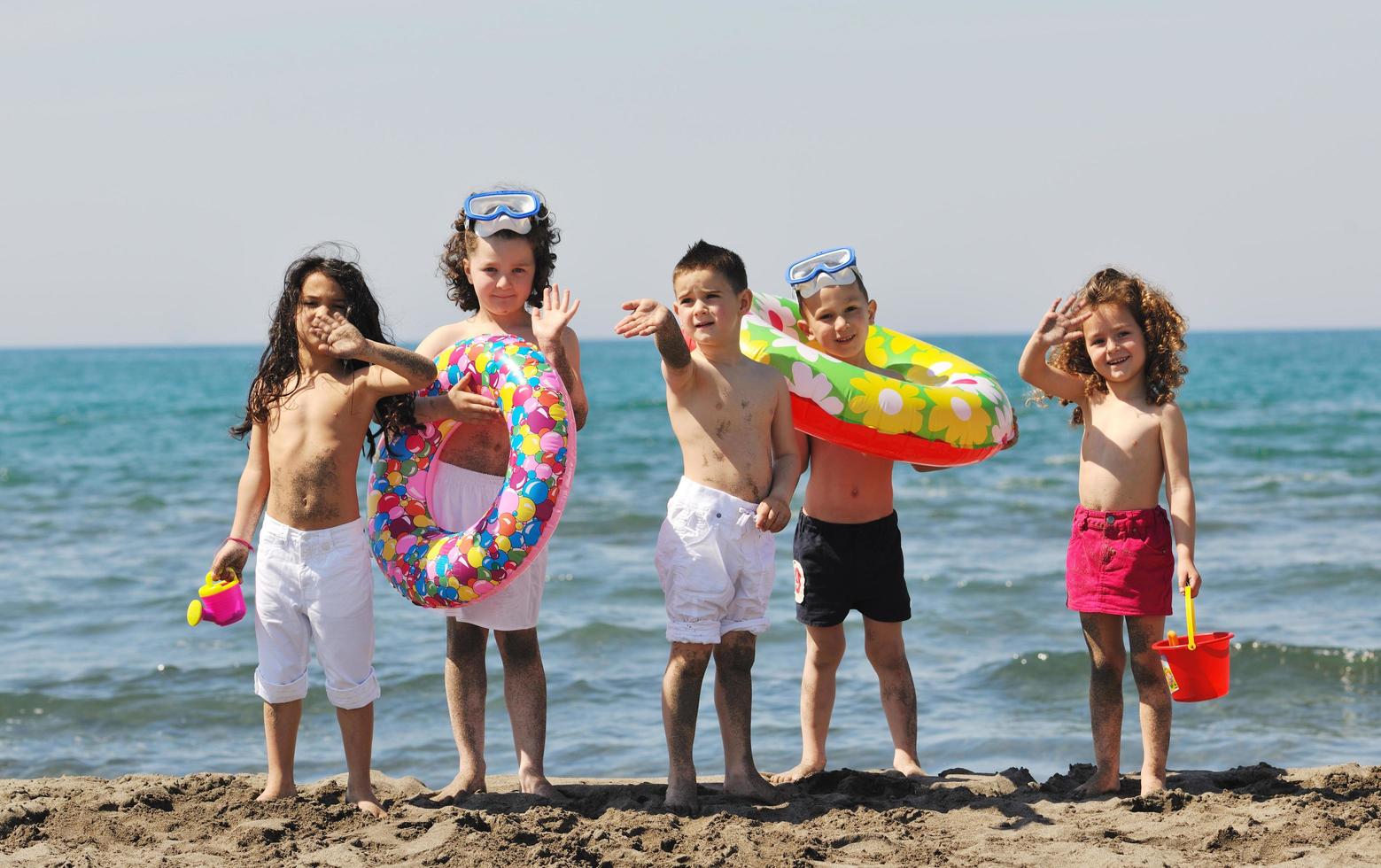 Kindergruppe hat Spaß und spielt mit Strandspielzeug foto