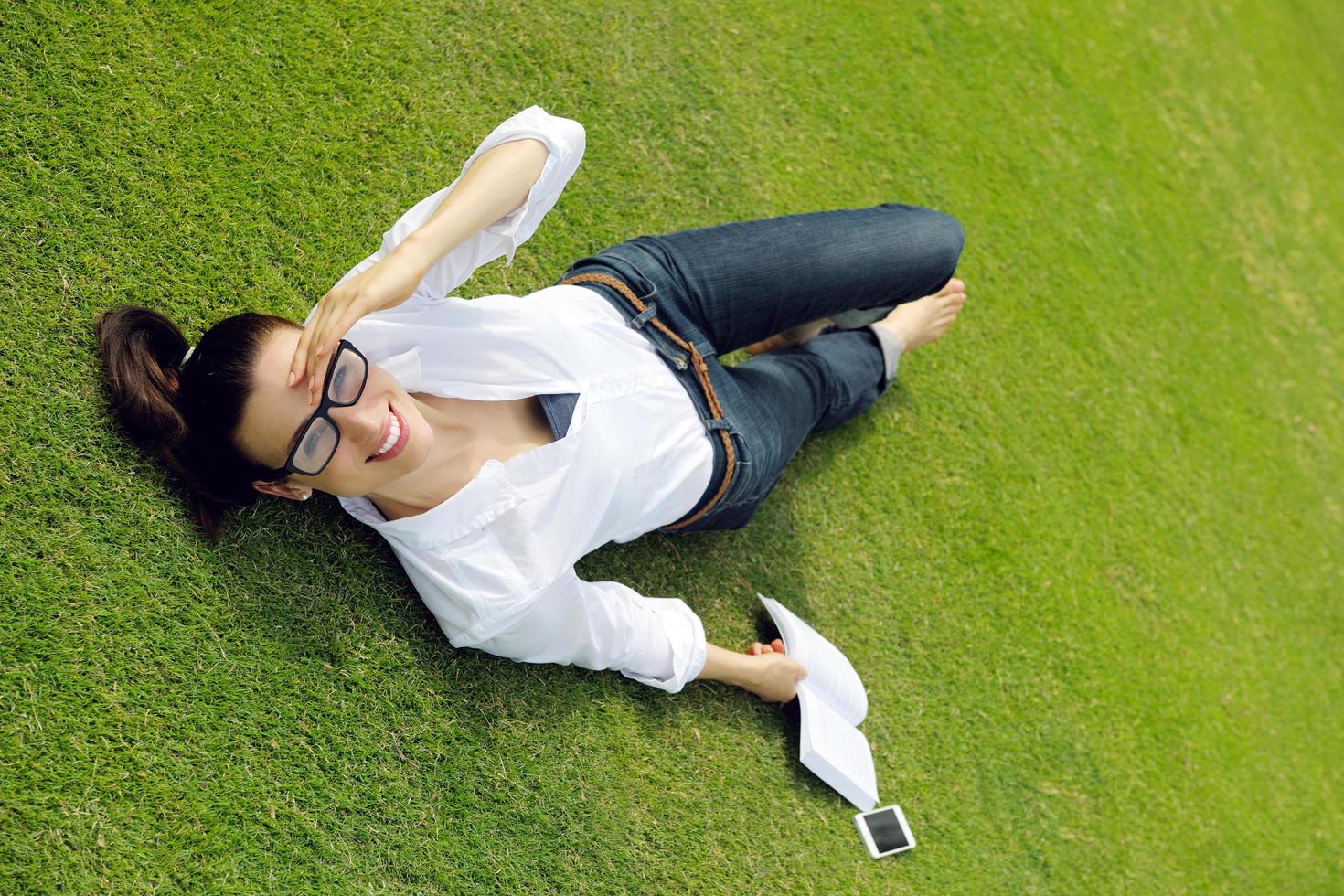 junge Frau, die ein Buch im Park liest foto