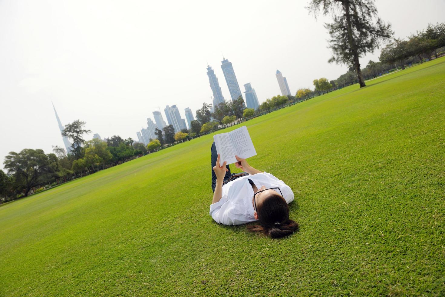 junge Frau, die ein Buch im Park liest foto