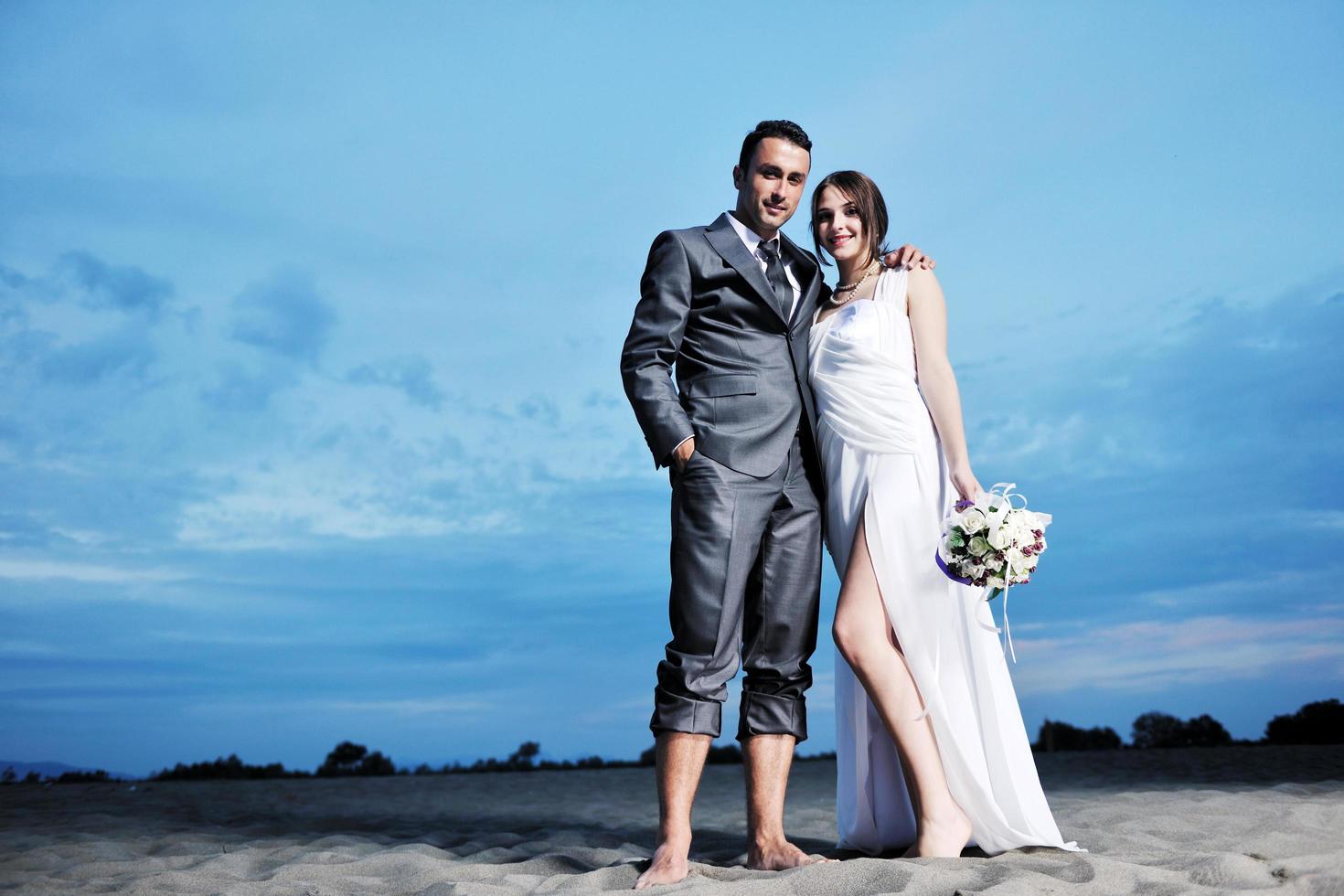 romantische Strandhochzeit bei Sonnenuntergang foto