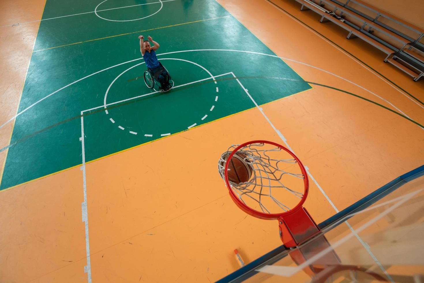 Abschleppfoto eines Kriegsveteranen, der Basketball in einer modernen Sportarena spielt. das Konzept des Sports für Menschen mit Behinderungen foto