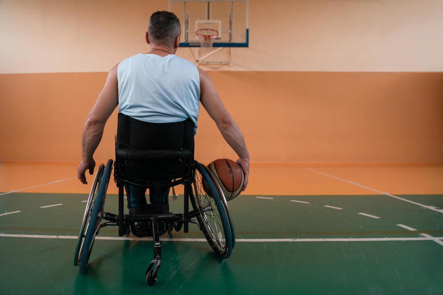 Nahaufnahme von Rollstühlen und behinderten Kriegsveteranen, die auf dem Platz Basketball spielen foto