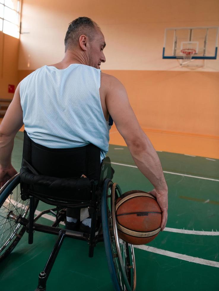 Nahaufnahme von Rollstühlen und behinderten Kriegsveteranen, die auf dem Platz Basketball spielen foto