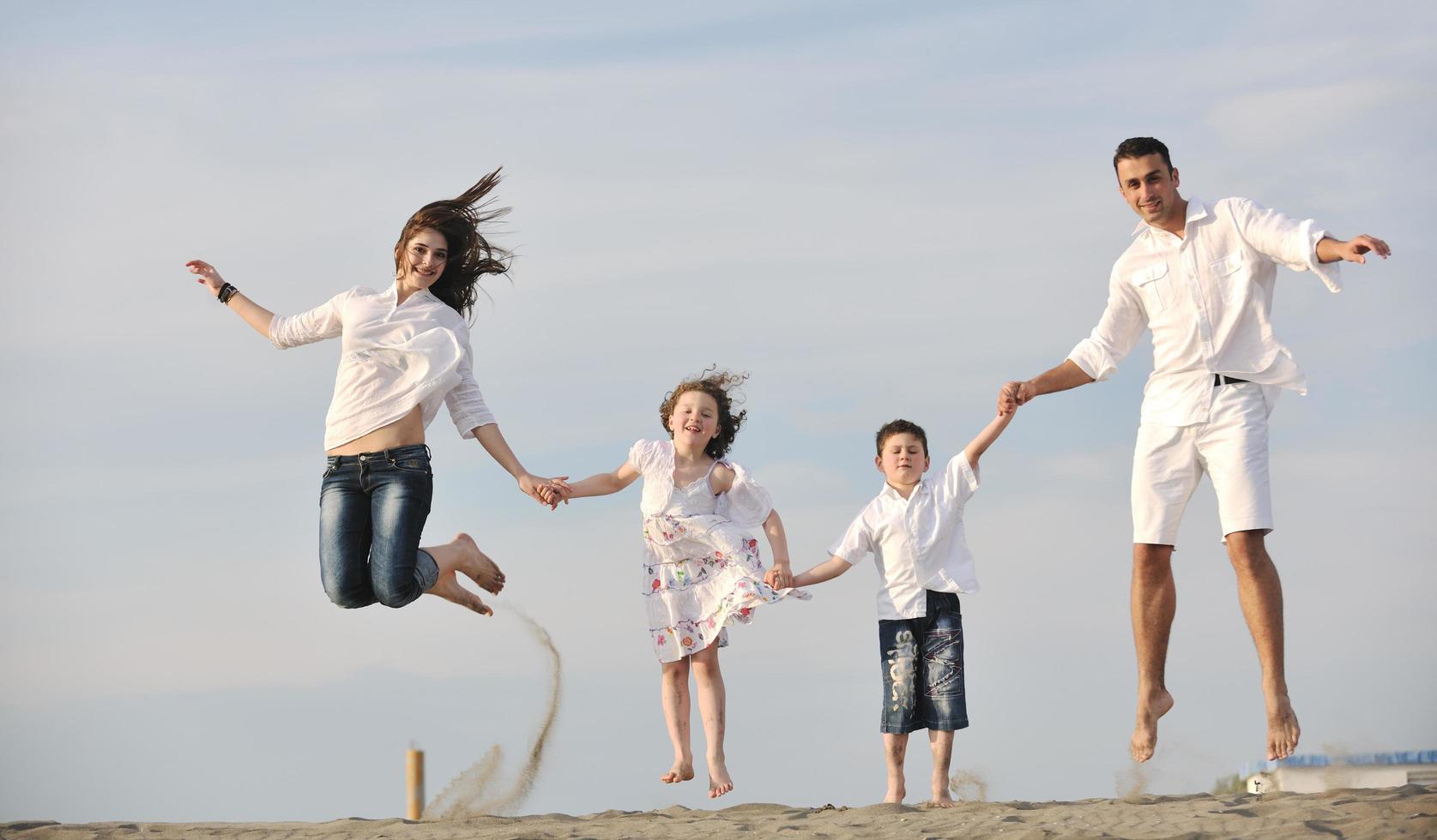 glückliche junge familie hat spaß am strand foto