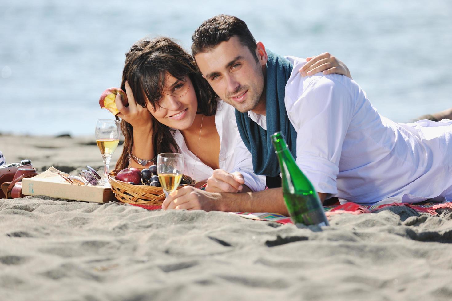 junges Paar beim Picknick am Strand foto