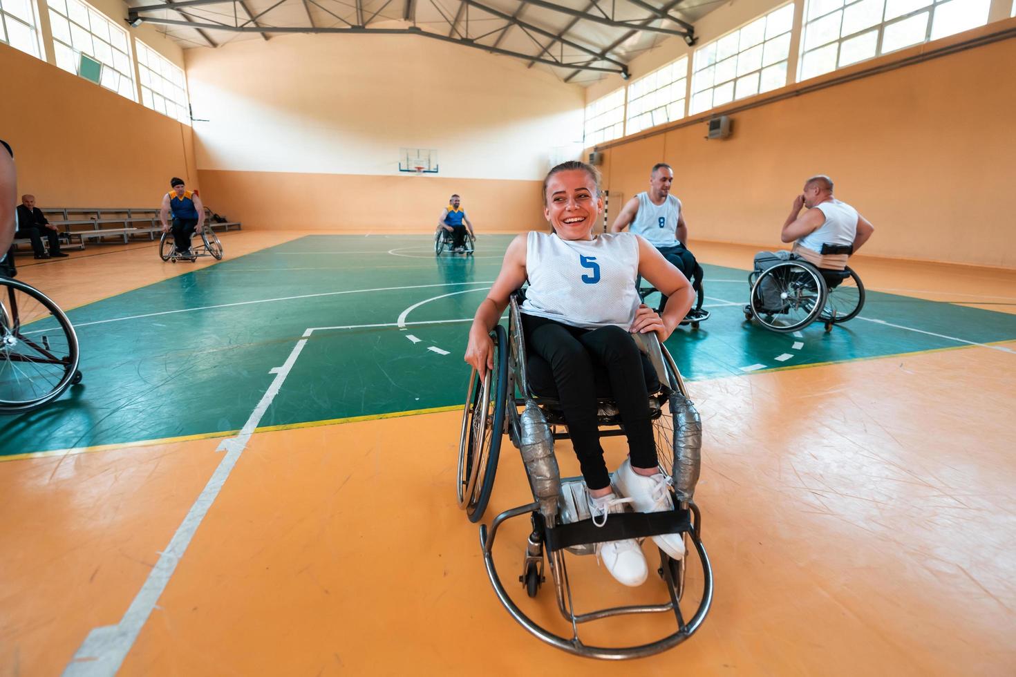 ein Porträt einer Frau mit einer Behinderung, die in einem Rollstuhl sitzt und auf den Beginn eines Basketballspiels wartet. selektiver Fokus foto