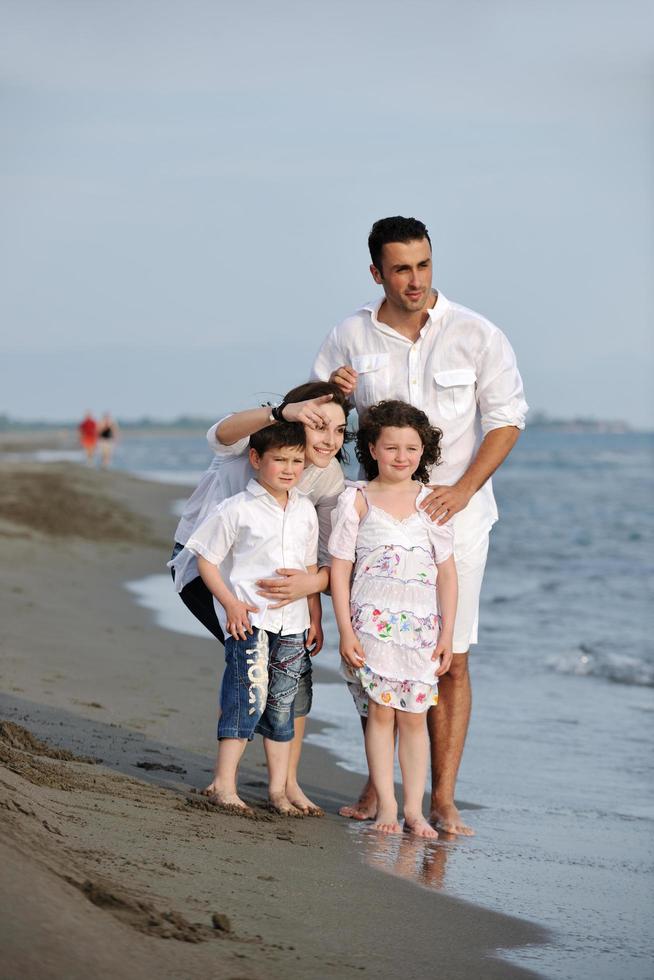 glückliche junge familie hat spaß am strand foto