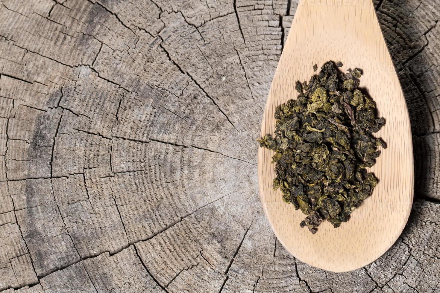 Löffel mit Oolong-Tee auf hölzernem Hintergrund foto