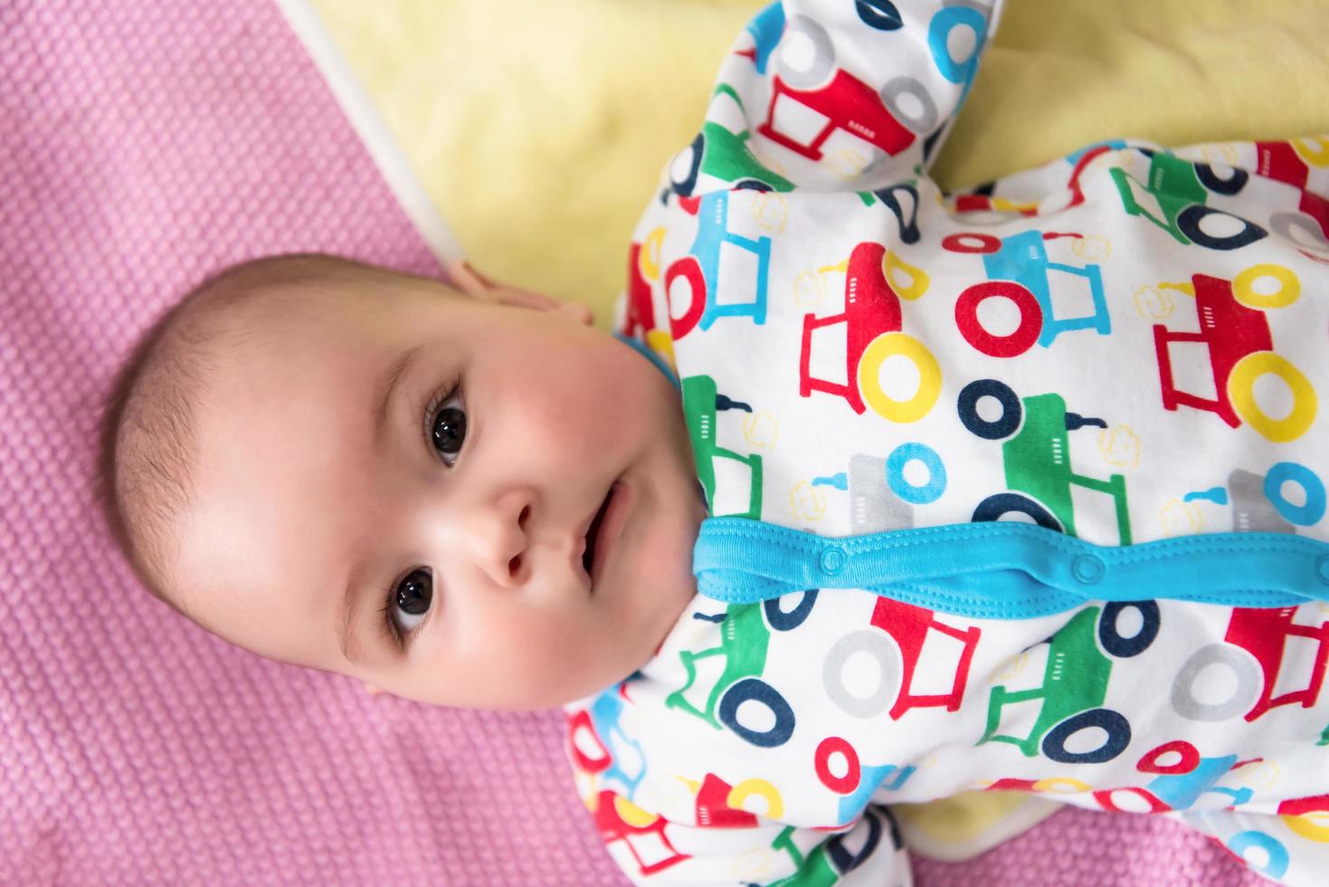 Draufsicht auf neugeborenes Baby, das auf bunten Decken liegt foto