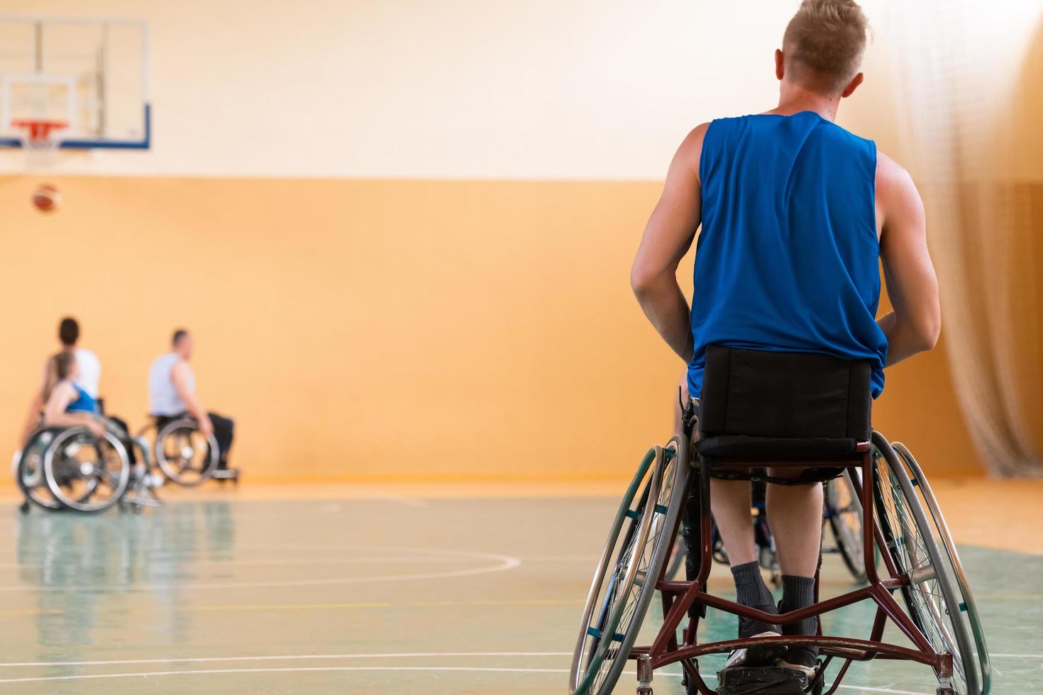 Nahaufnahme von Rollstühlen und behinderten Kriegsveteranen, die auf dem Platz Basketball spielen foto