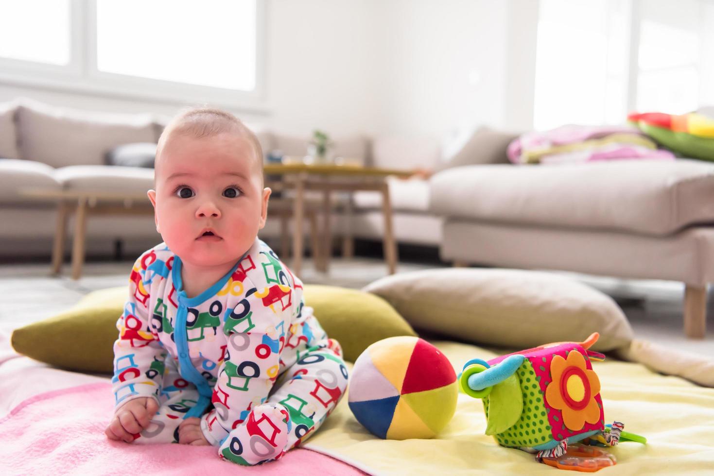 Neugeborenes Baby, das auf bunten Decken sitzt foto