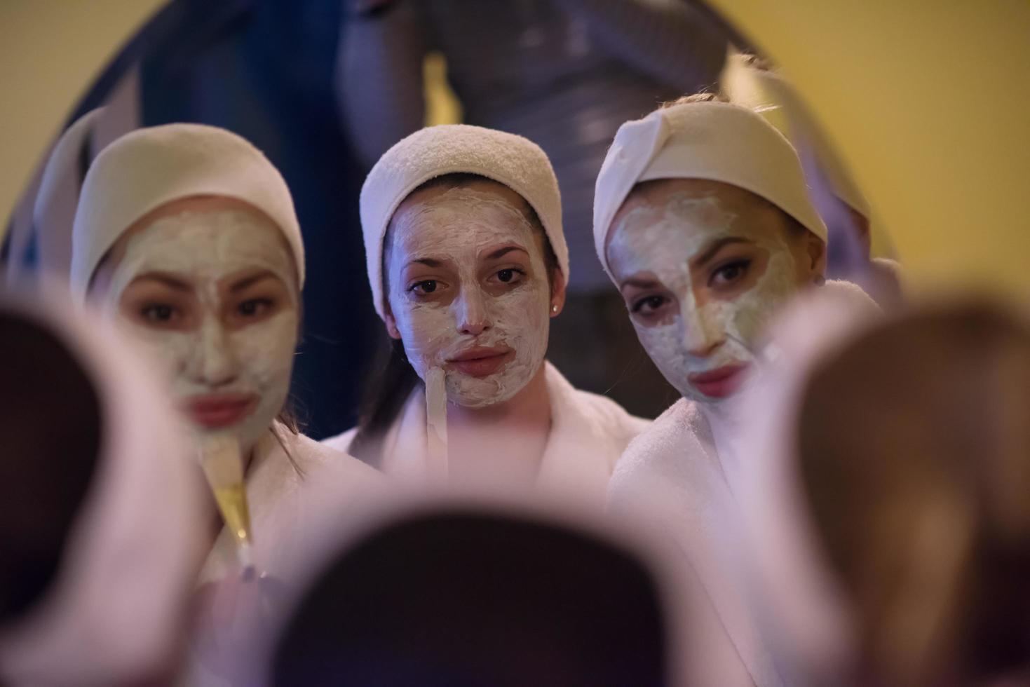 Frauen, die Gesichtsmasken ins Badezimmer legen foto
