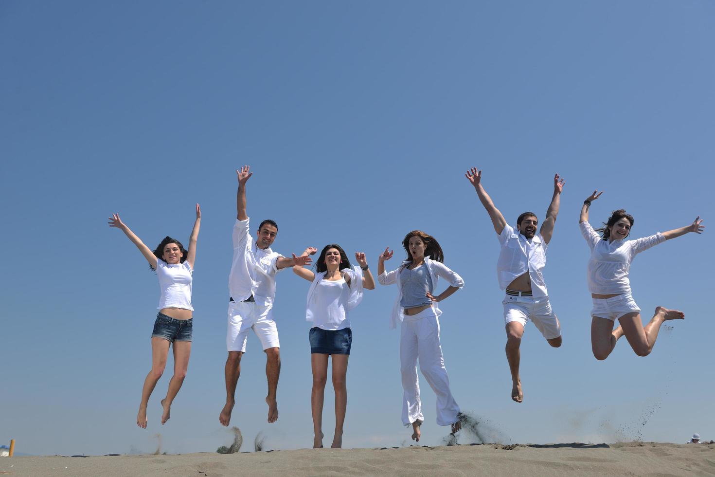 Happy People Group hat Spaß und läuft am Strand foto