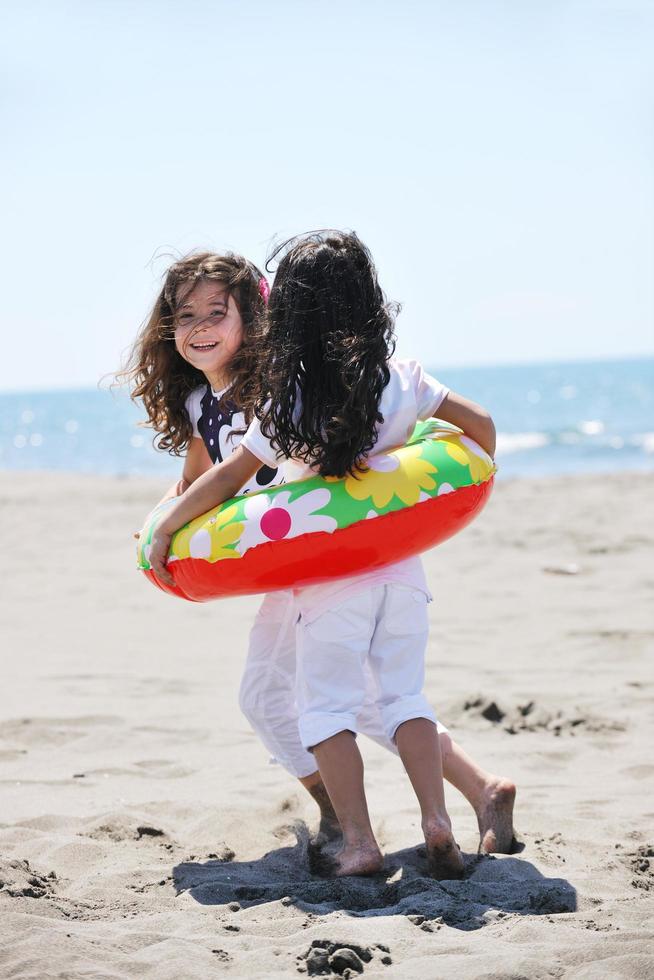 glückliche Kindergruppe, die am Strand spielt foto